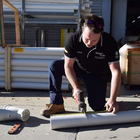 a Water Tight Canberra team member cutting a pipe