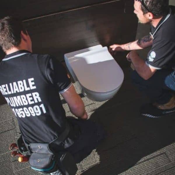 two men repair toilet